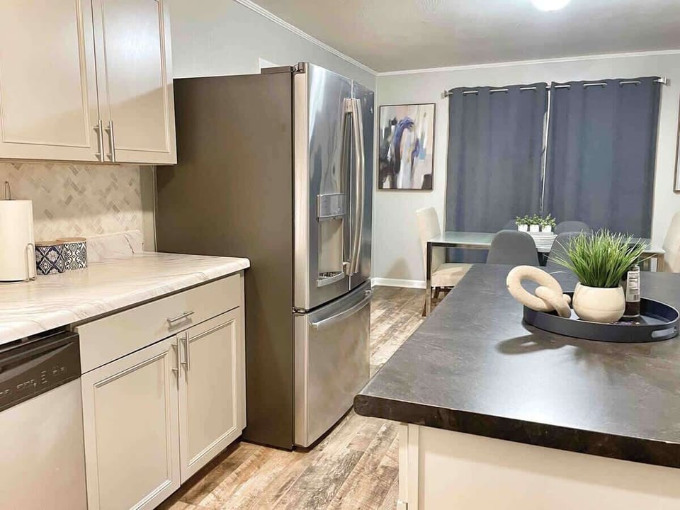 Bright, modern kitchen with dishwasher, full fridge, and ample storage.
