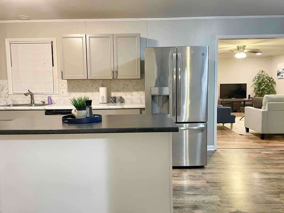 Open kitchen with full-size refrigerator, cookware, and coffee supplies included