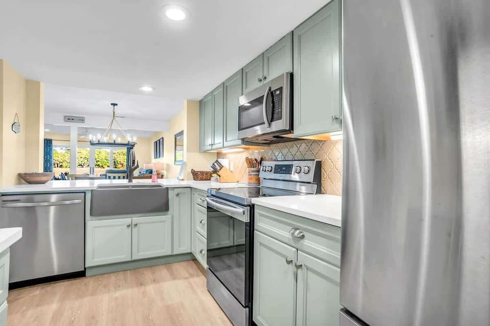 Your spacious kitchen awaits with modern appliances, beautiful sage cabinetry, and everything needed to create memorable meals during your stay.