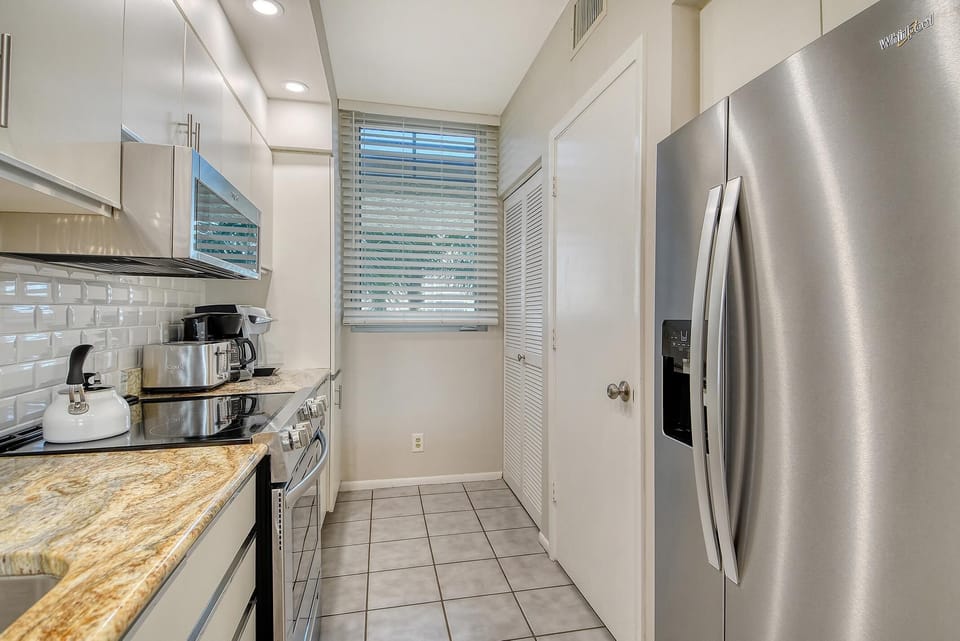 Bright, modern kitchen with stainless steel appliances and cozy window light