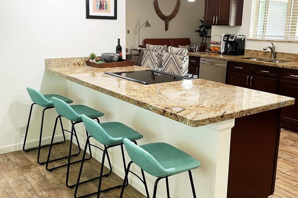 open kitchen with bar seating for 4 and seating for 8 at dining table