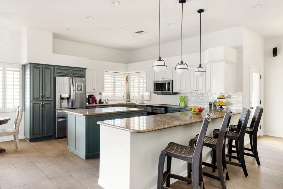 Spacious chef's kitchen featuring an oversized island, granite countertops, stainless steel appliances, and abundant cabinetry. Designed for cooking, entertaining, and gathering with family and friends.