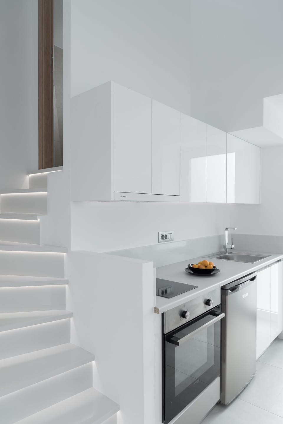 A white brushed kitchenette features and oven, mini fridge and all the basic 