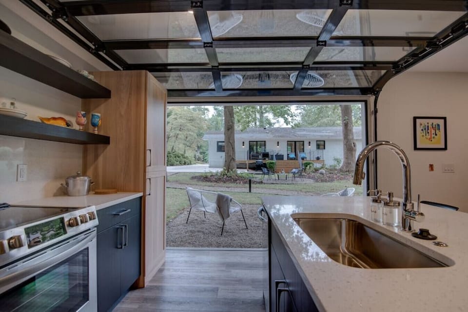 Glass garage door opens to the outdoor sitting area