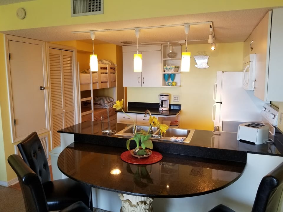 Dining area and kitchen. Note the bunk beds back in the hallway on the left.