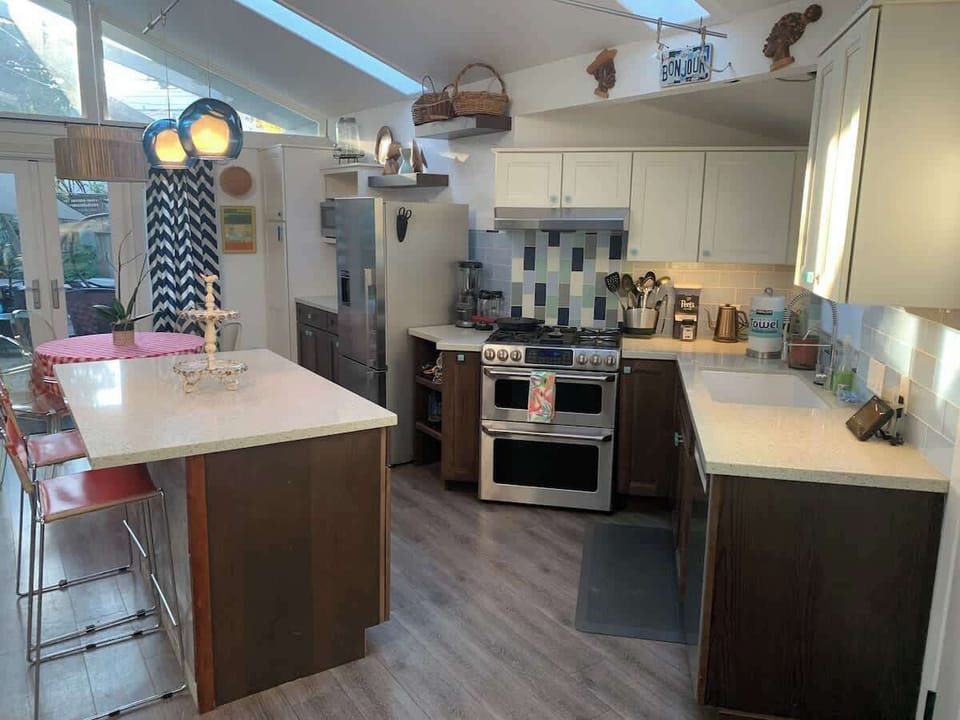 Bright, fully equipped kitchen with modern appliances and seating—perfect for families cooking together, couples enjoying wine nights, or business travelers who prefer a home-cooked meal.