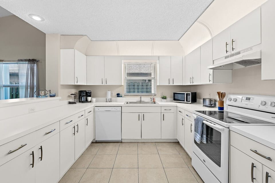 Fully equipped kitchen with flat stove top, refrigerator and freezer, dishwasher, coffee maker and more. (food and coffee not provided)