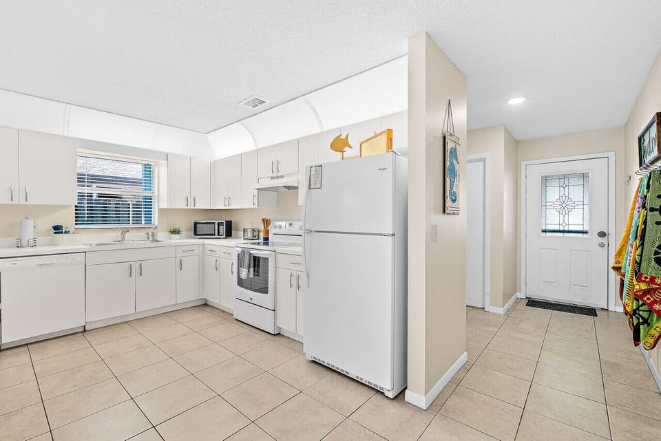 Fully equipped kitchen with flat stove top, refrigerator and freezer, dishwasher, coffee maker and more. (food and coffee not provided)