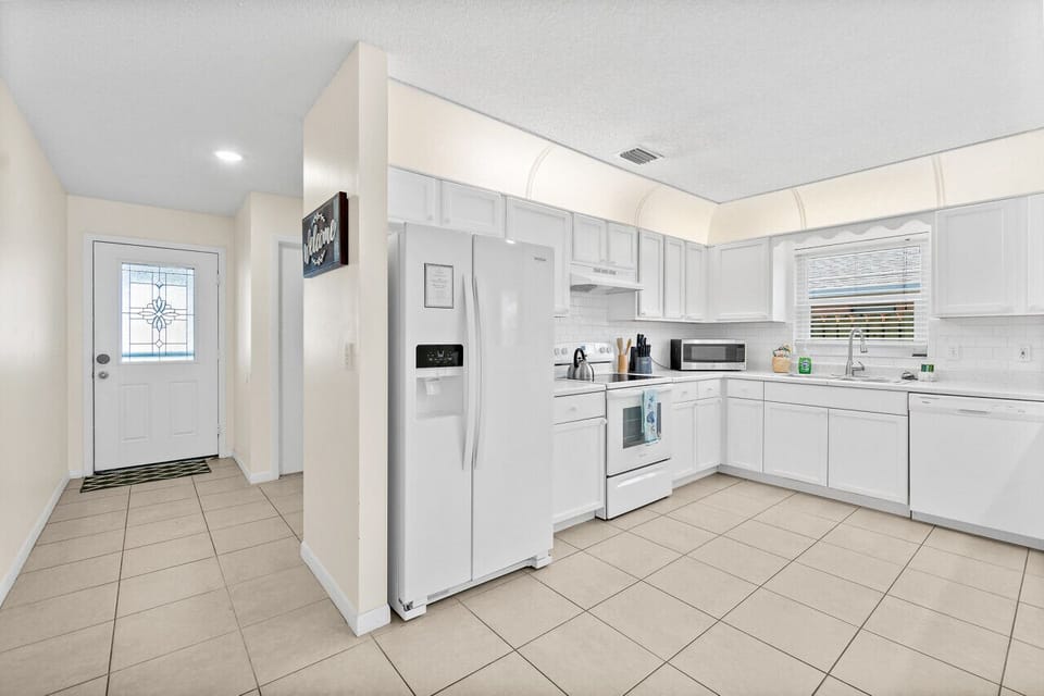 Fully equipped kitchen with flat stove top, refrigerator and freezer, dishwasher, coffee maker and more. (food and coffee not provided)