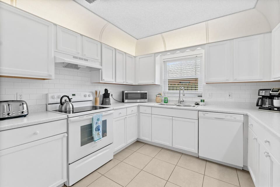 Fully equipped kitchen with flat stove top, refrigerator and freezer, dishwasher, coffee maker and more. (food and coffee not provided)