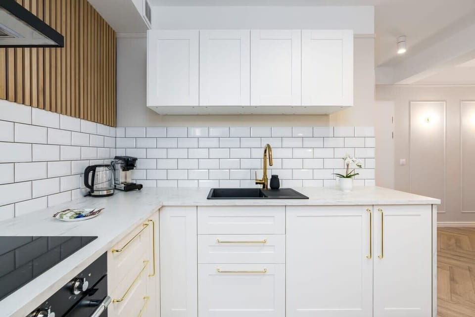 Another view of the kitchen featuring elegant brass accents and a tiled backsplash.
