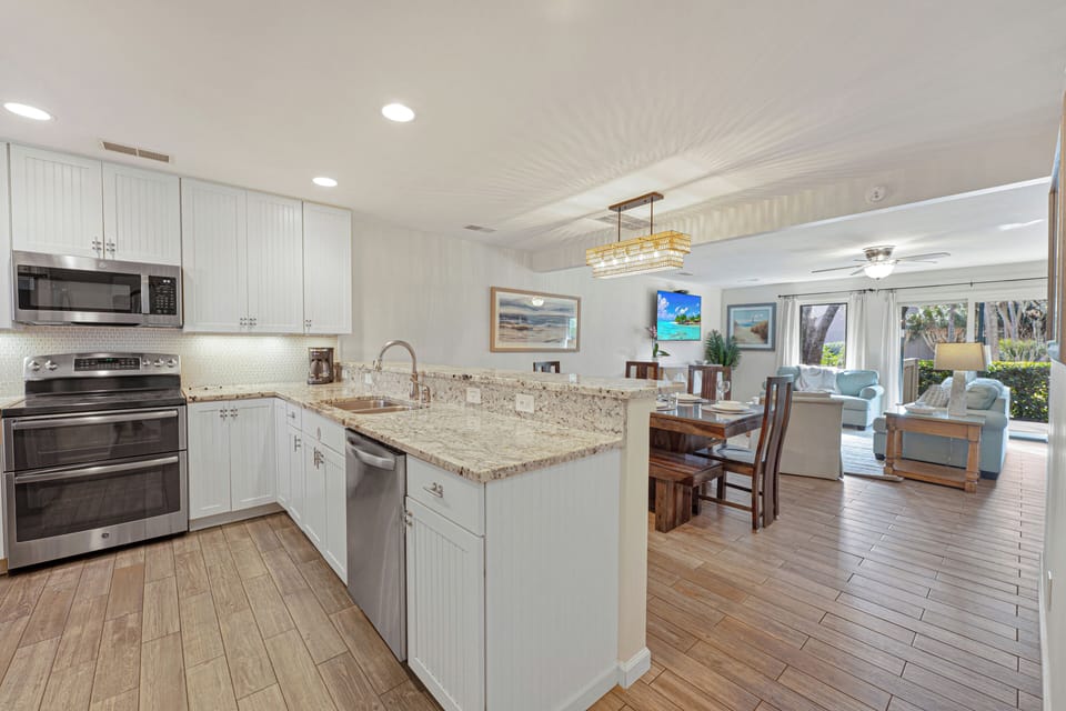 Expansive granite countertops provide plenty of prep space, with a large sink overlooking the living area.