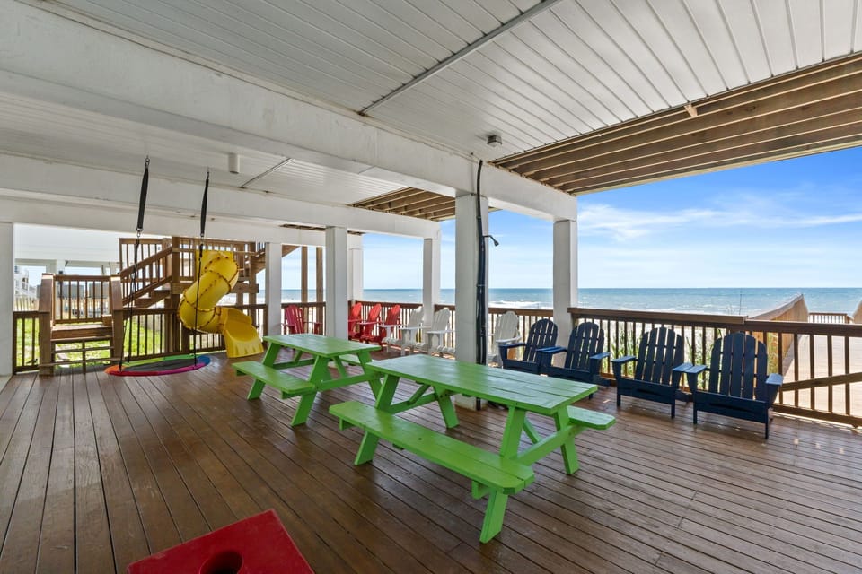 The covered deck overlooks the Gulf, offering colorful seating, a playground, and ocean breezes—an ideal spot for family gatherings and coastal relaxation.