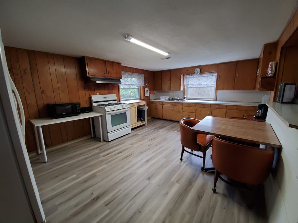 Kitchen & dining - Refrigerator, stove, microwave, coffee maker & 3 seat table.