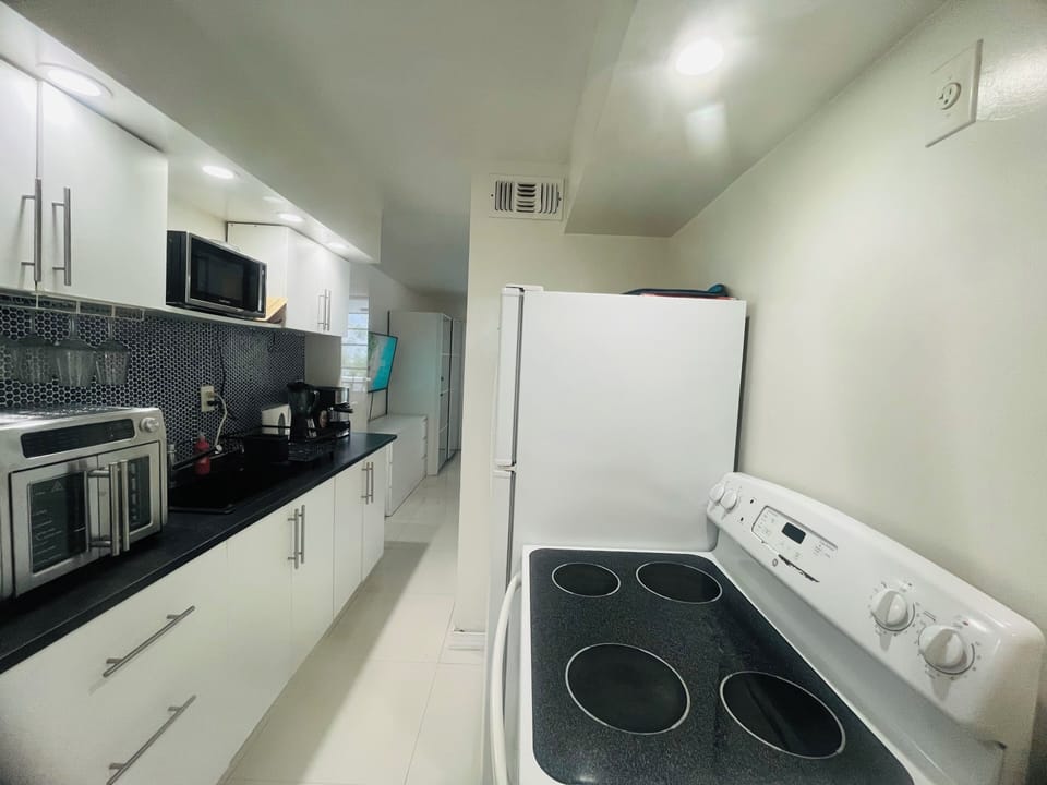 Fully equipped kitchen with cooktop, convection/air fryer oven, microwave...