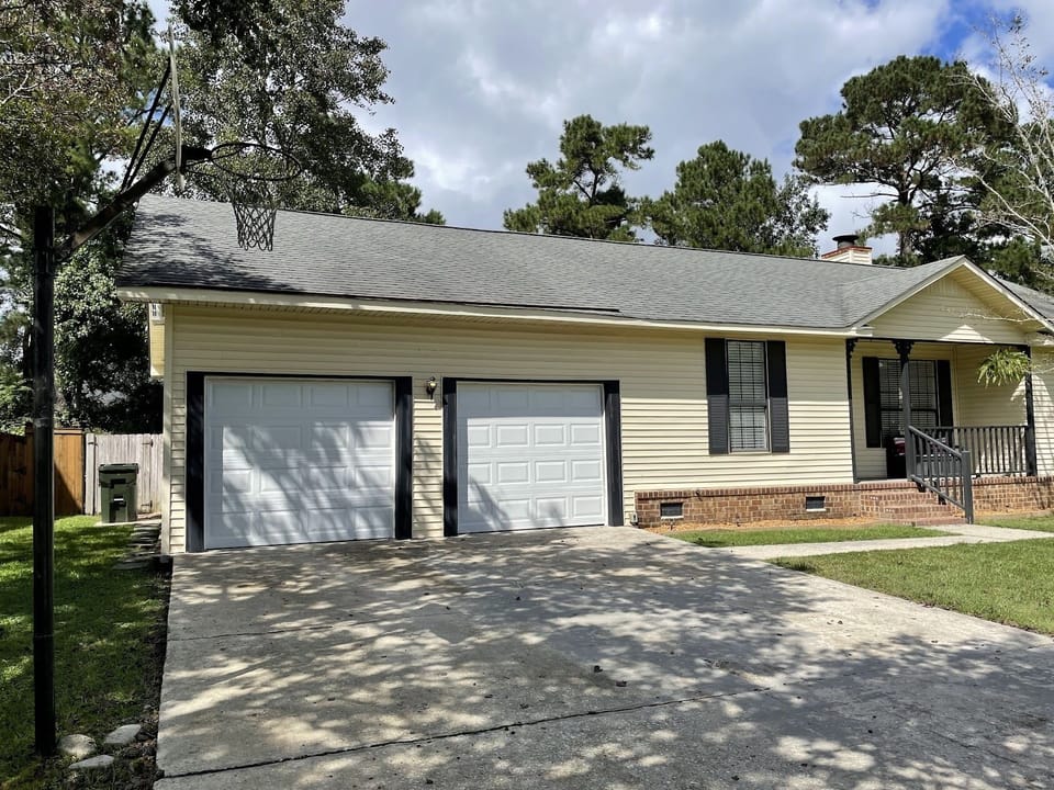 Front of house, basketball hoop in driveway.