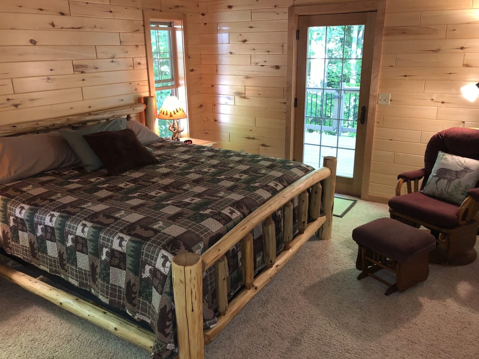 Main level bedroom with king size bed, glider, and walk-in closet