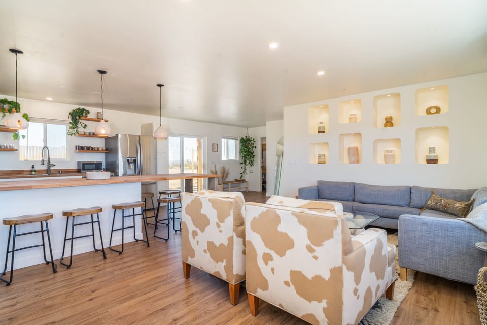 Living room complete with cow chairs and niche wall to display ceramics.
