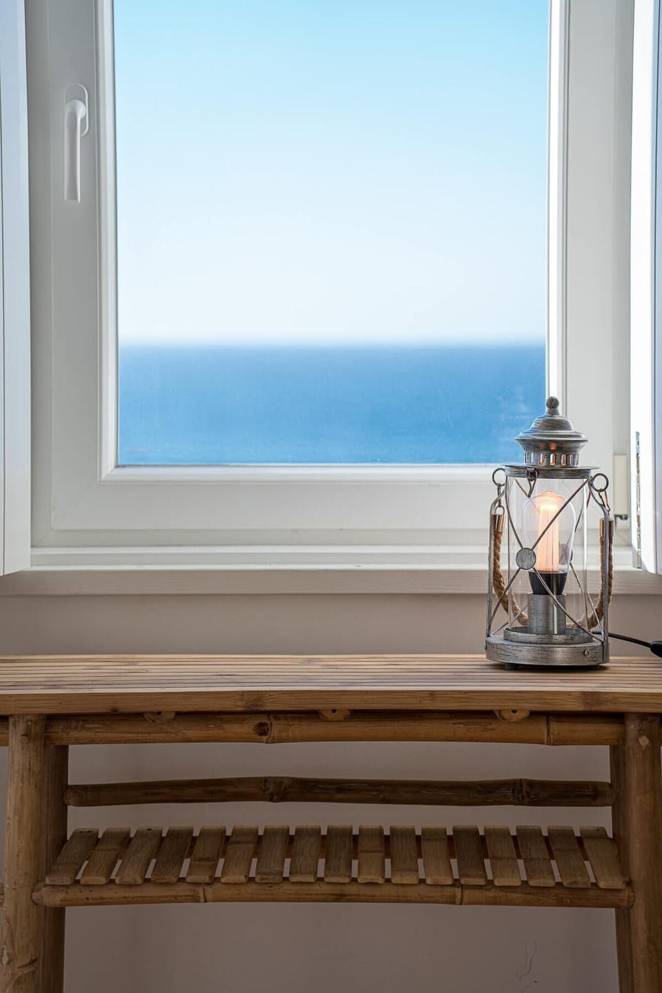 Wooden windowsill with lit lantern overlooking blue sea — Villa Sublime, holiday villa in Sintra