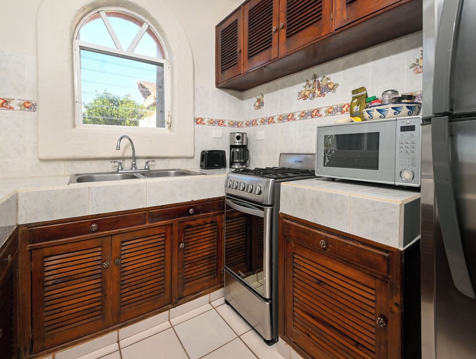 Your fully equipped kitchen features rich wood cabinetry and modern appliances, perfect for creating memorable meals during your stay.