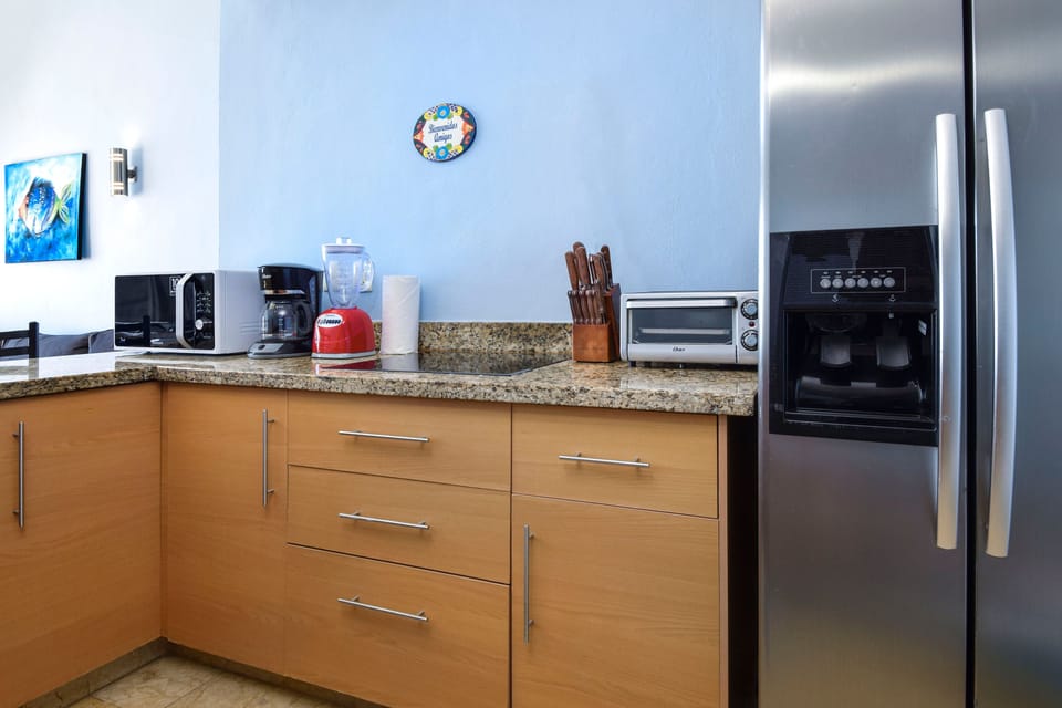 Kitchen features toaster oven, stovetop, fridge and more