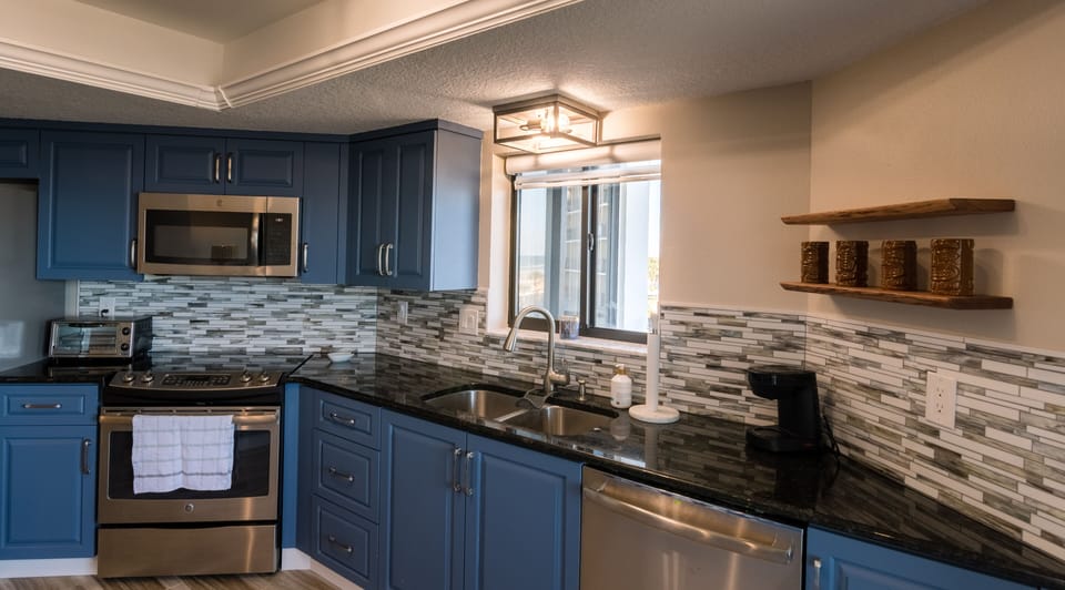 Fully equipped kitchen with glasstop stove and large eating bar.