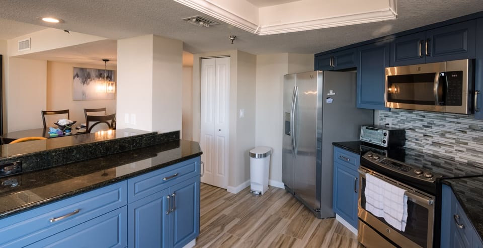 Fully equipped kitchen with glasstop stove and large eating bar.