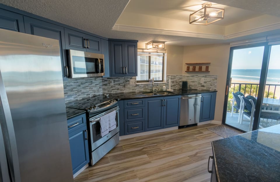 Fully equipped kitchen with glasstop stove and large eating bar.