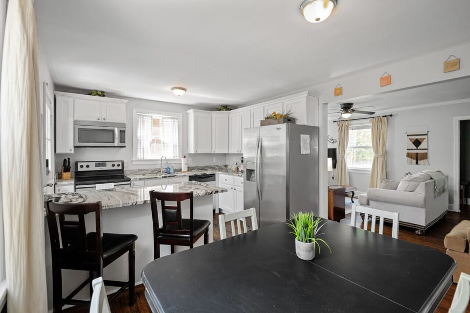 Dine in style! A spacious table for 4 plus additional seating at the kitchen bar for quick bites. Large windows flood the space with light, making it the perfect spot to gather.