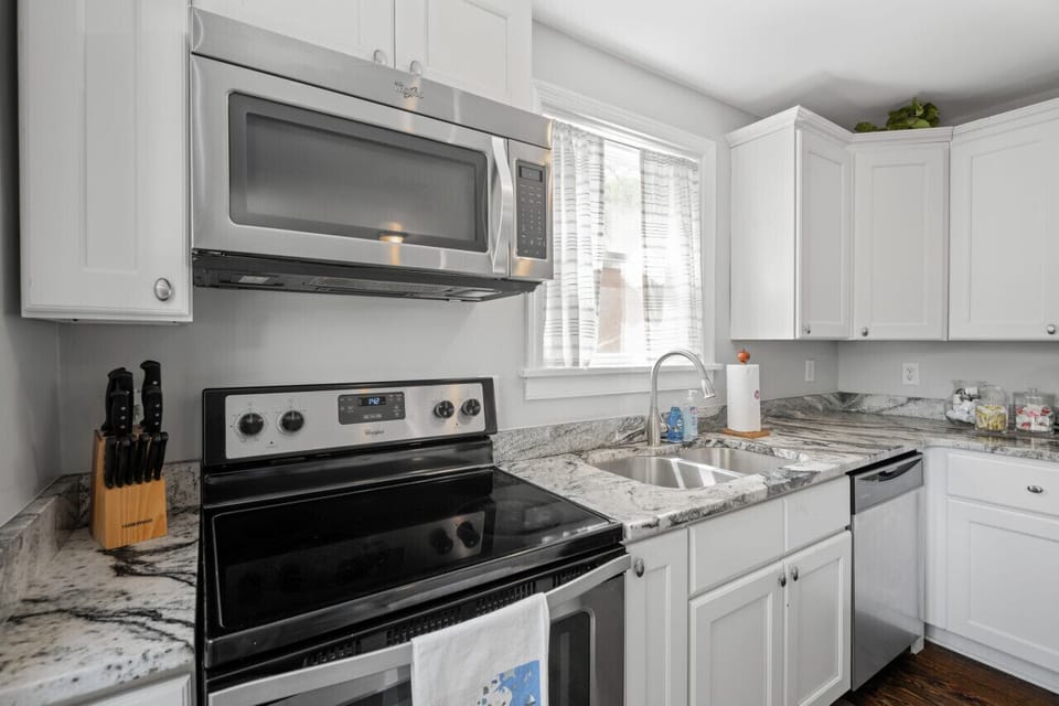 Sleek marble countertops, modern appliances, and a spacious kitchen island bar with stool seating. This fully stocked kitchen is a chef`s dream!