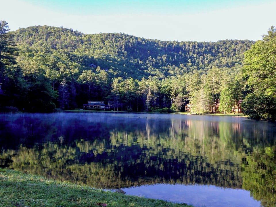 Breathe in morning calm as mist rises over the lake.