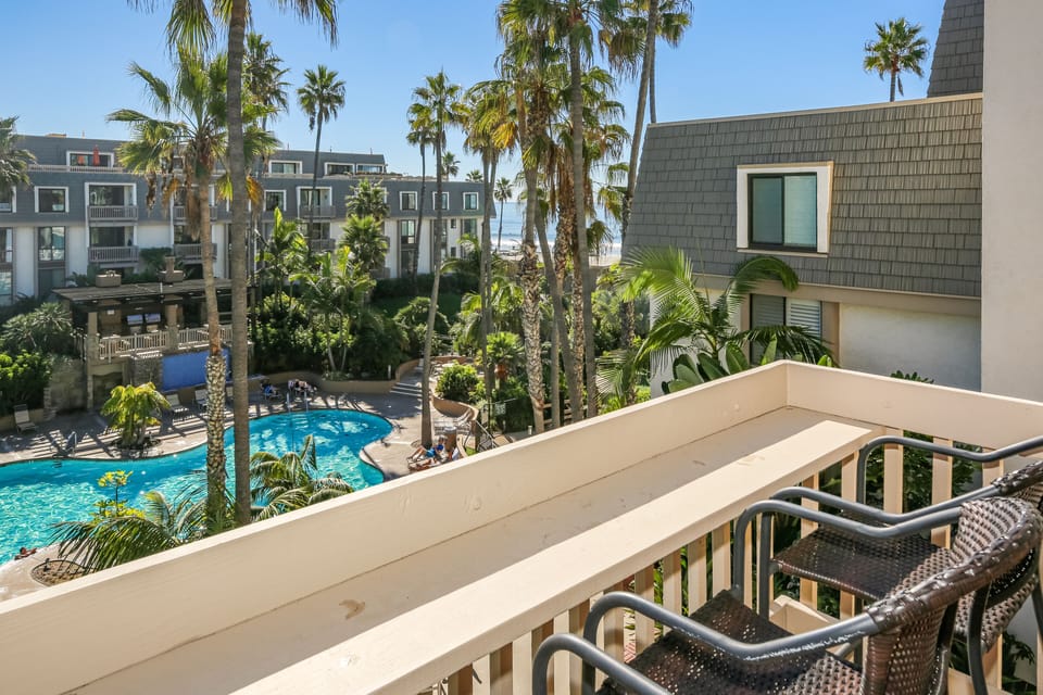 Lovely view from the downstairs balcony including the pool and a peek of the ocean waves.