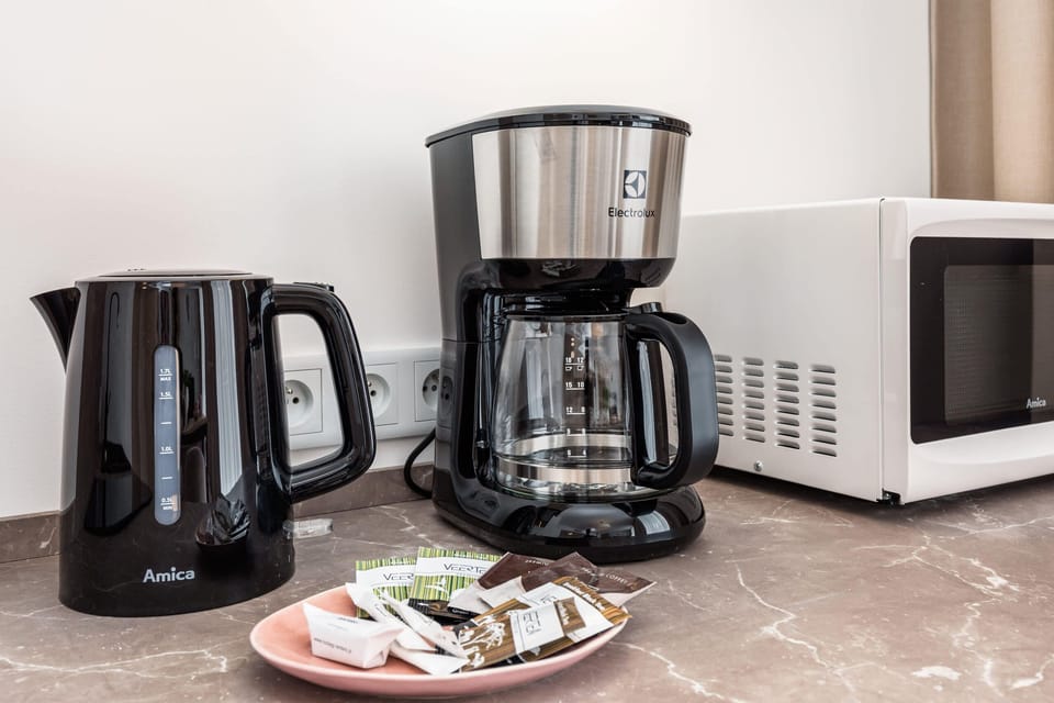 A coffee station with a coffee maker, cups, and a welcoming setup for guests.
