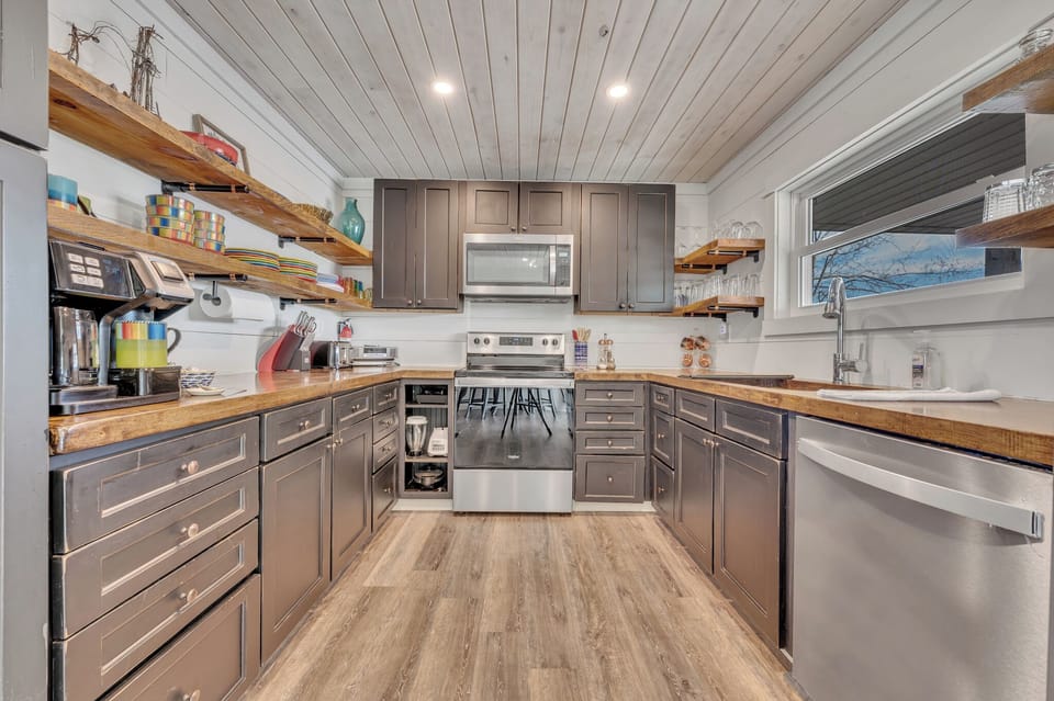 Spacious kitchen with open shelving and every modern convenience. 