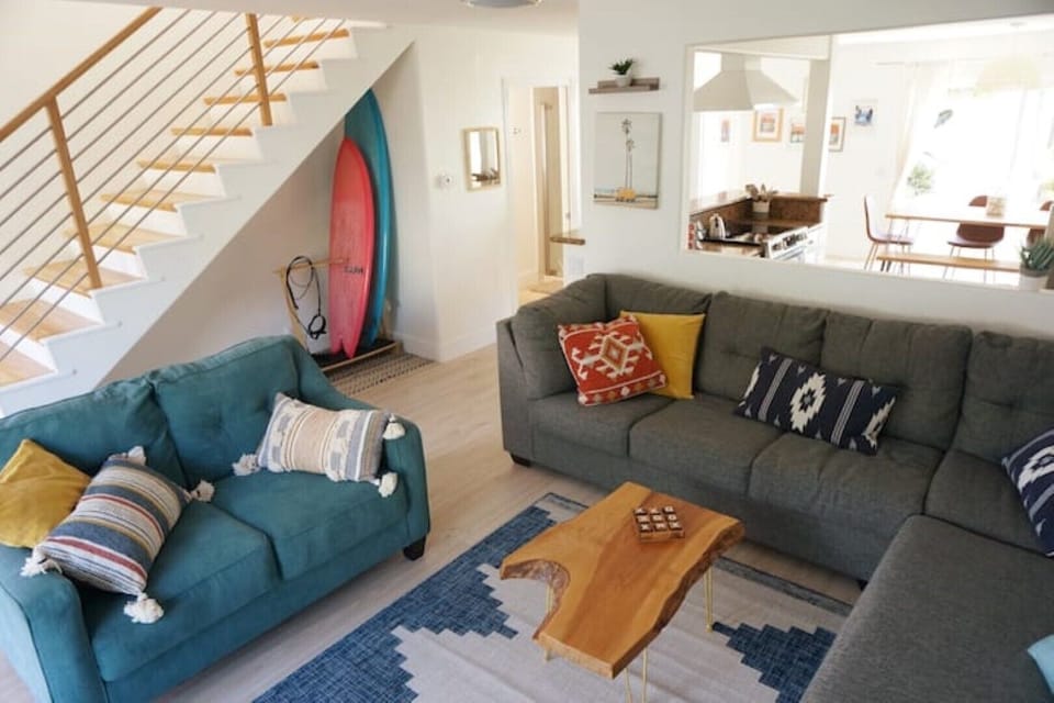 Living room area with plenty of seating and surf board rack 
