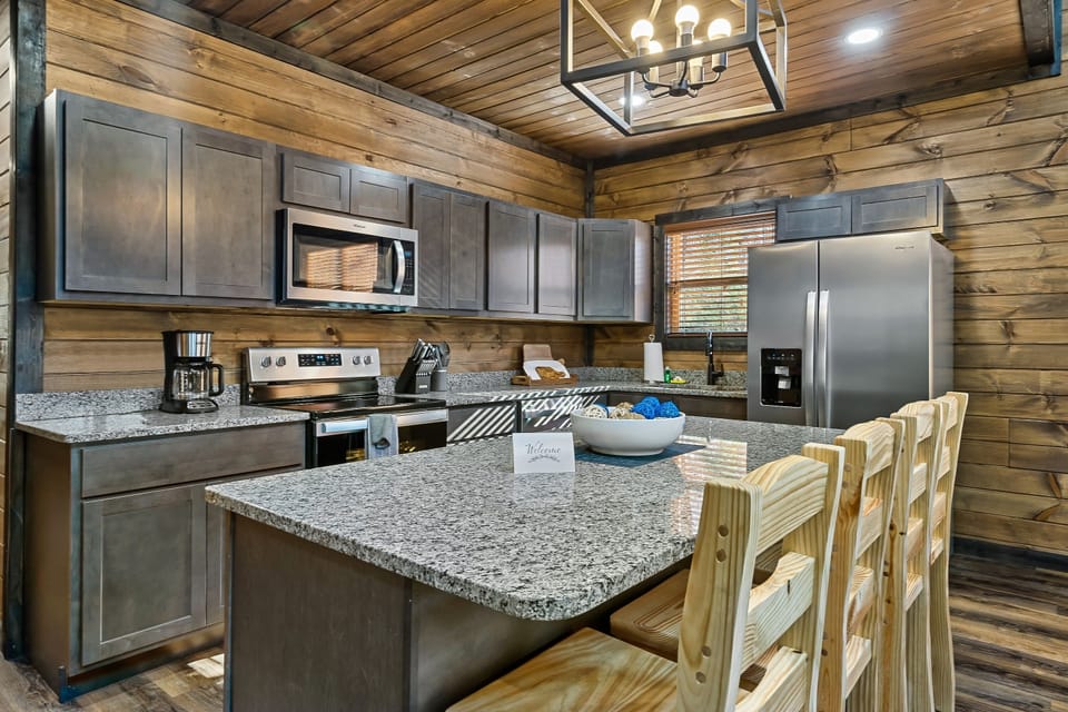 Fully-supplied kitchen with stainless steel appliances and granite countertops. 
