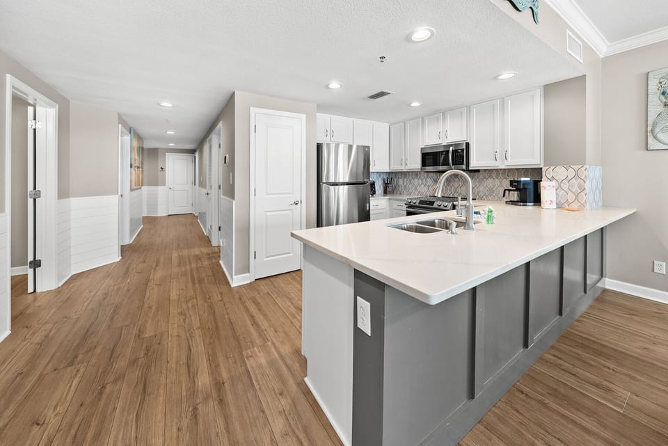 Your modern kitchen awaits with sleek white cabinets, quartz countertops, and stainless steel appliances - perfect for creating memorable meals together.
