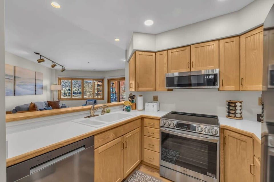 The fully-equipped kitchen overlooks the living room and dining area and includes two bar stools for additional seating.