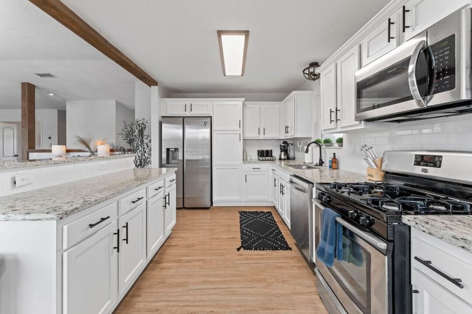 Cook, gather, and connect in this fully stocked kitchen—perfect for big groups with a gas stove, Keurig coffee, charming sitting area, and balcony views over the pool.