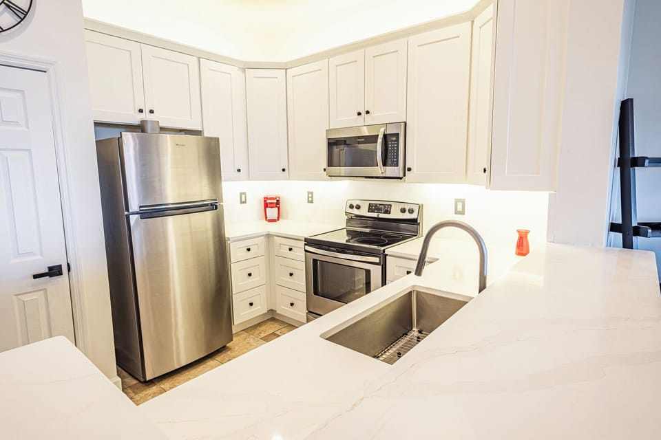 Bright Kitchen Detail: Deep Basin Sink, Ample Storage, and Under-Cabinet Lighting
