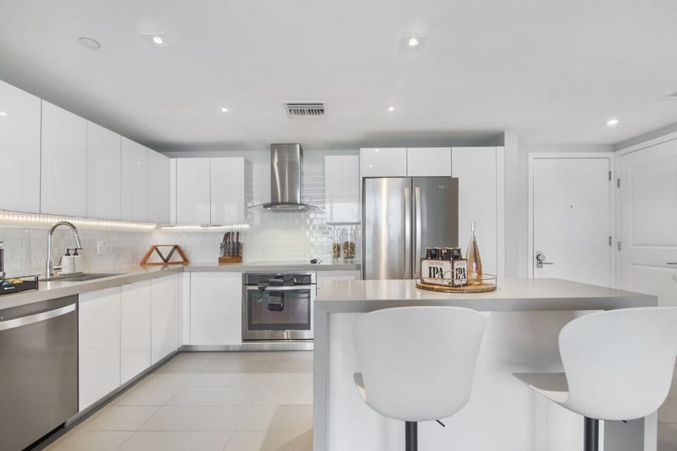 Stocked Kitchen: The kitchen has beautiful white quartz countertops, stainless steel kitchen appliances, a stove top hood and all of the cooking essentials for those who enjoy cooking and hosting.