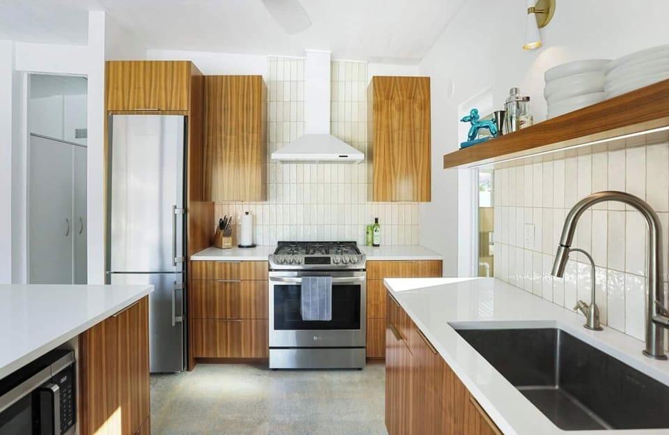 ully stocked modern kitchen with stainless steel appliances, dishwasher, and coffee maker.