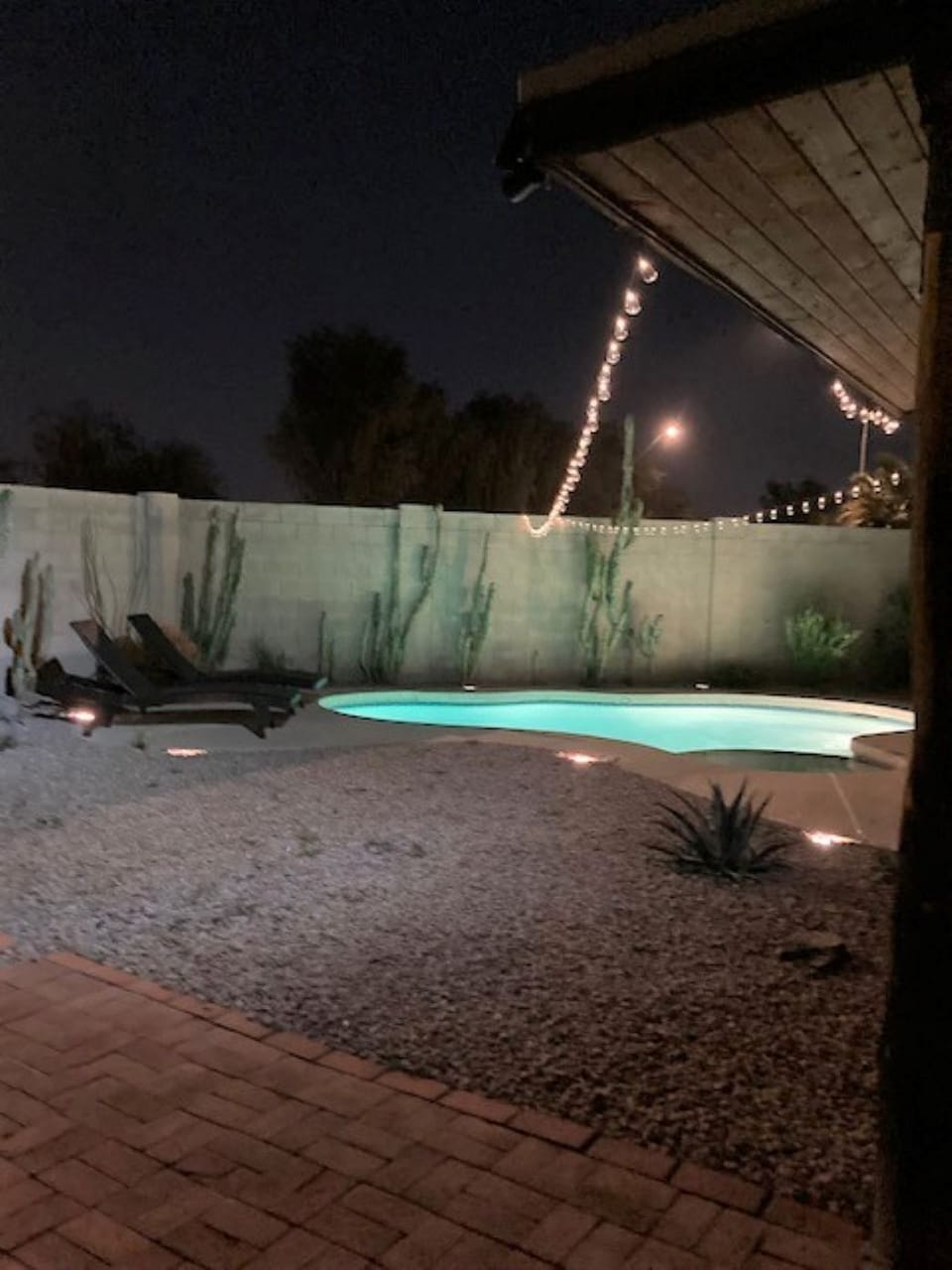 Pool, hot tub and lounge chairs in the evening.  