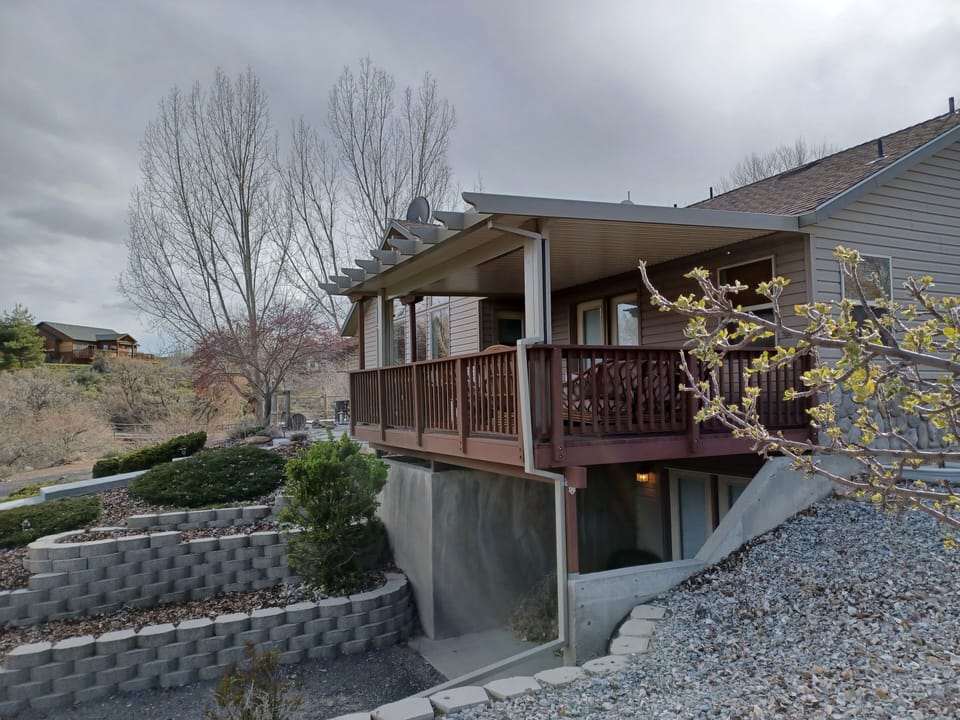 Backyard covered deck overlooks creek view