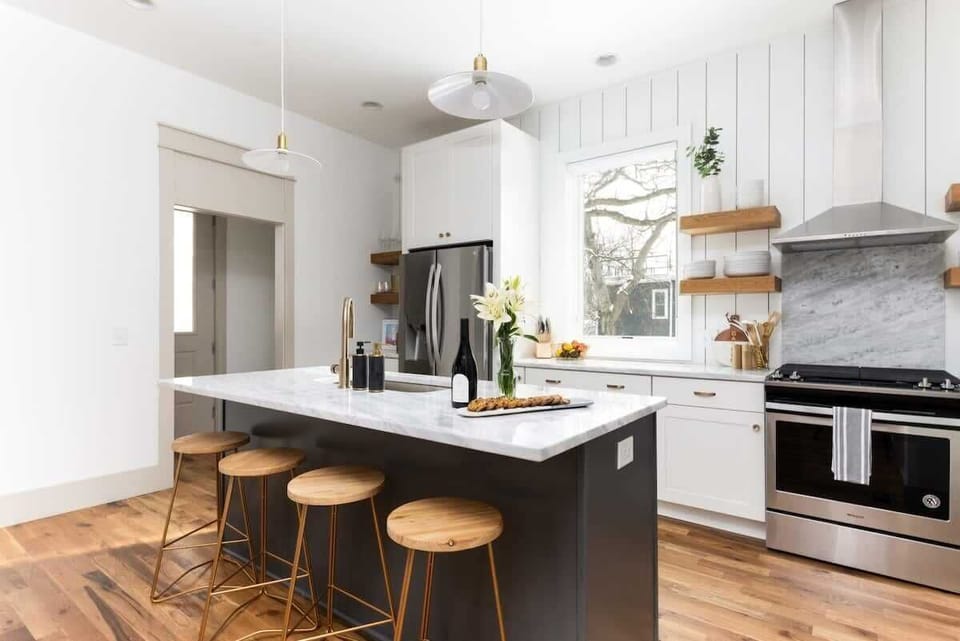 The fully equipped kitchen features a large island with four barstools, allowing guests to socialize while cooking.