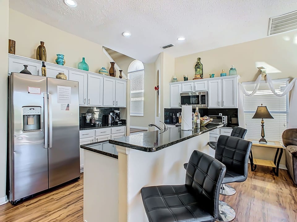 🍳 Open and spacious kitchen with bar seating, leading directly to the living and dining areas.