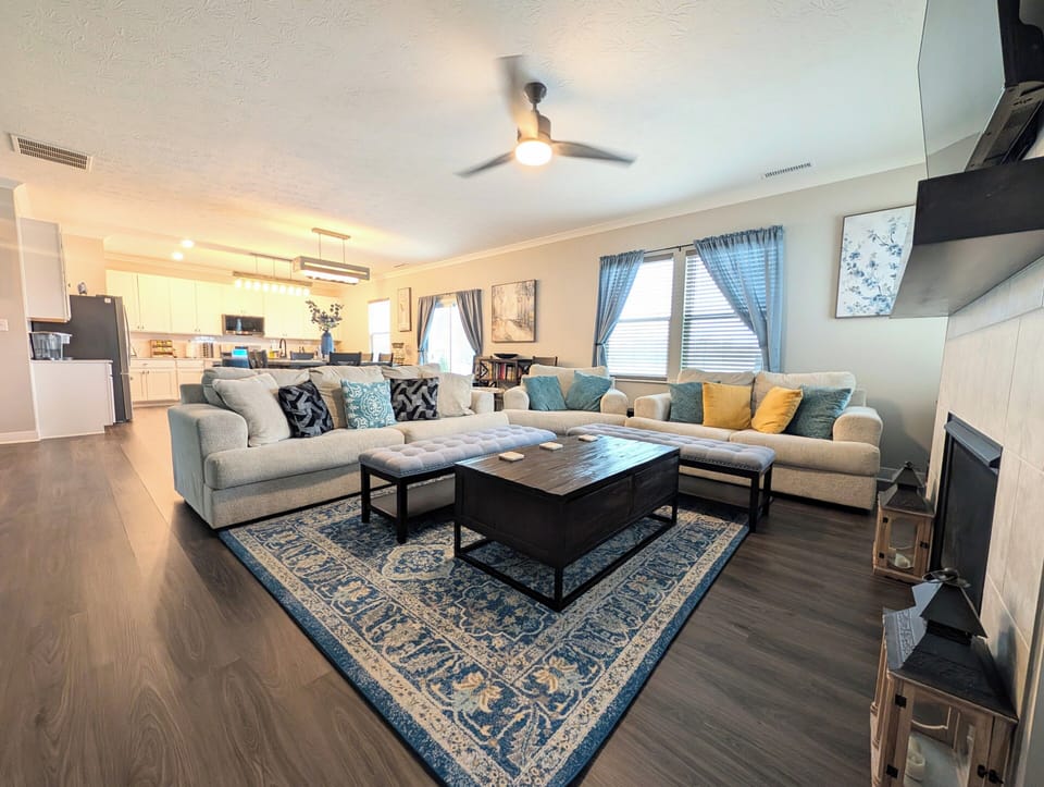 Great room with 65" smart tv, ceiling fan, gas fireplace and throw blankets