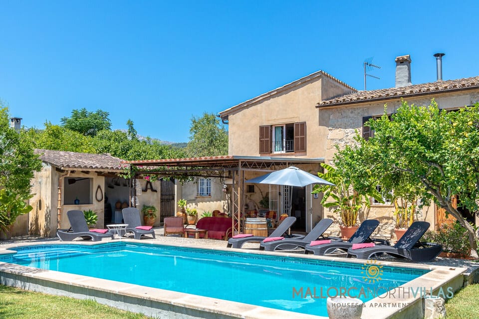 Villa facade with private swimming pool, sun loungers, pergola and Mediterranean garden, ideal for enjoying the rural surroundings.