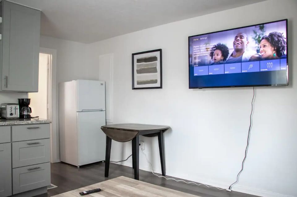 Bright living area with flat-screen TV, comfortable seating, and natural light.