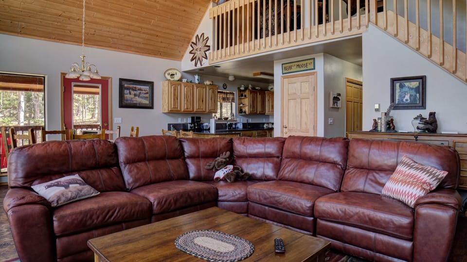 The living area features a large sectional focused on the woodburning fireplace and large screen with Dish TV.